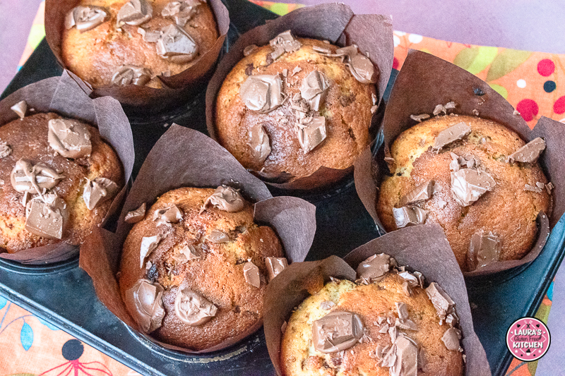 Close-up of moist chocolate chunk banana muffin with chopped chocolate on top.