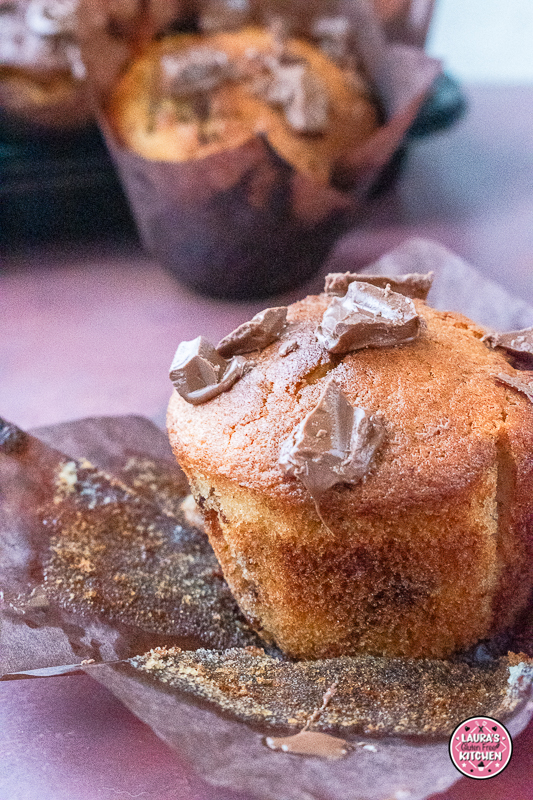 Close-up of moist chocolate chunk banana muffin with chopped chocolate on top.