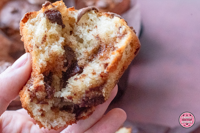 Close-up of moist chocolate chunk banana muffin with chopped chocolate on top.