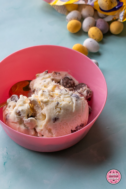 Scoops of mini egg ice cream with crushed Cadbury Mini Eggs in a bowl.